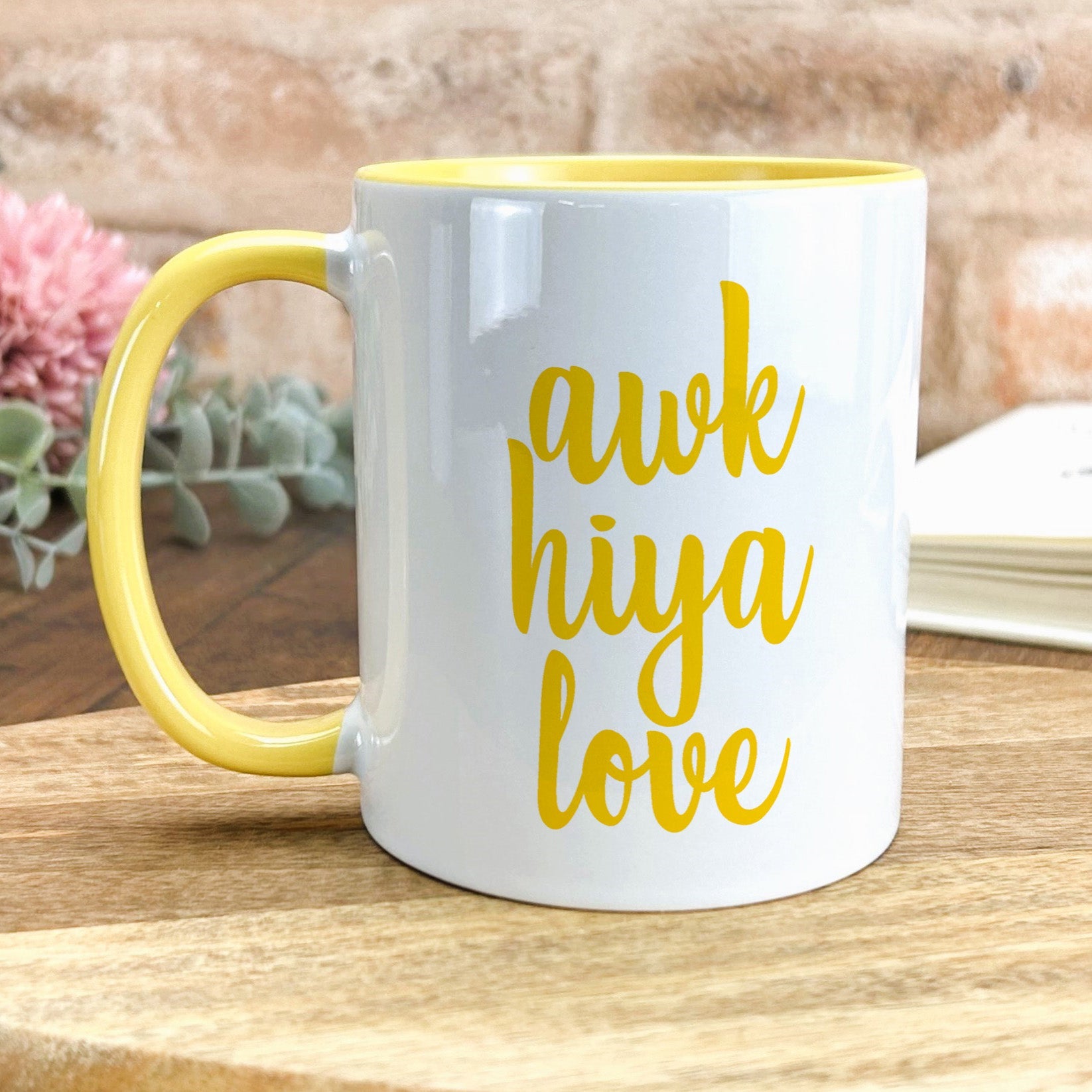 a yellow and white coffee mug sitting on top of a wooden table