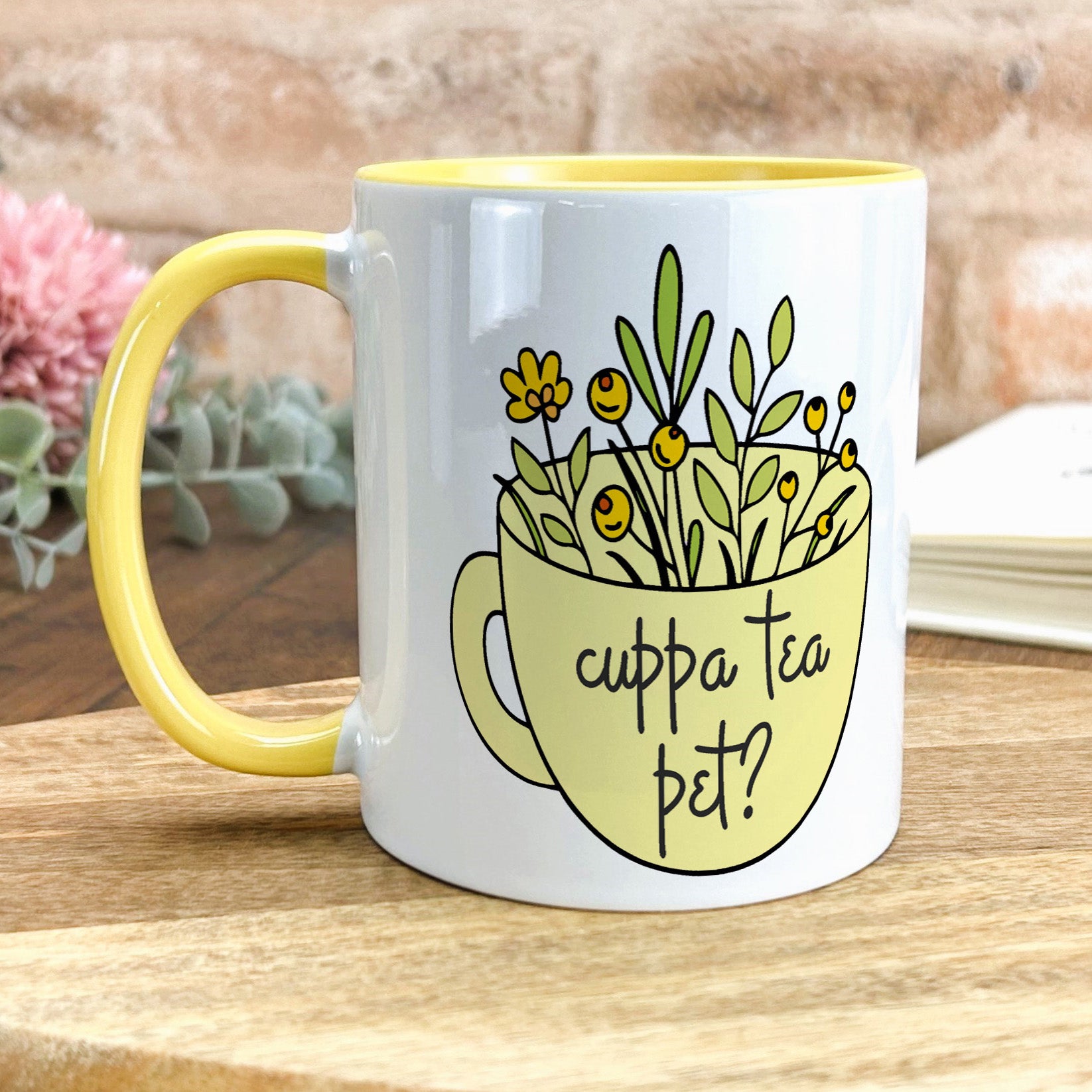 a yellow and white coffee mug with flowers in it