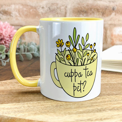 a yellow and white coffee mug with flowers in it