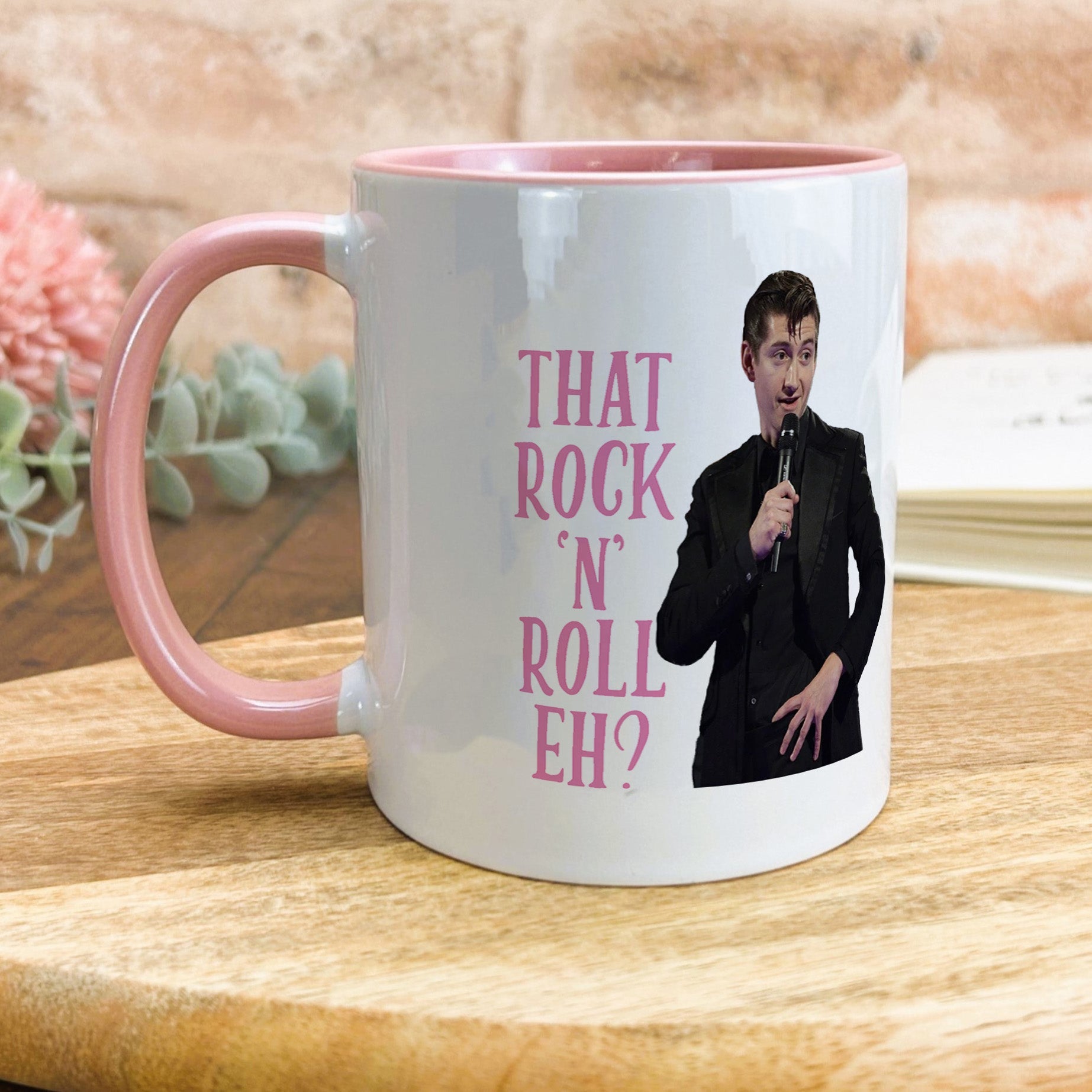 a pink and white coffee mug with a picture of a man holding a microphone