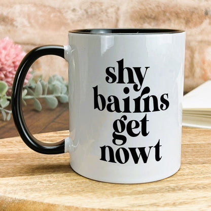 a black and white coffee mug sitting on top of a wooden table