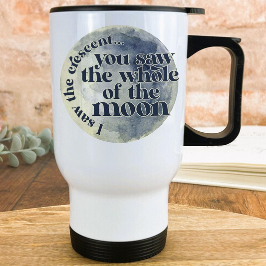 A white travel mug with a black handle, featuring a circular design with the text "You saw the whole of the moon" printed on it.