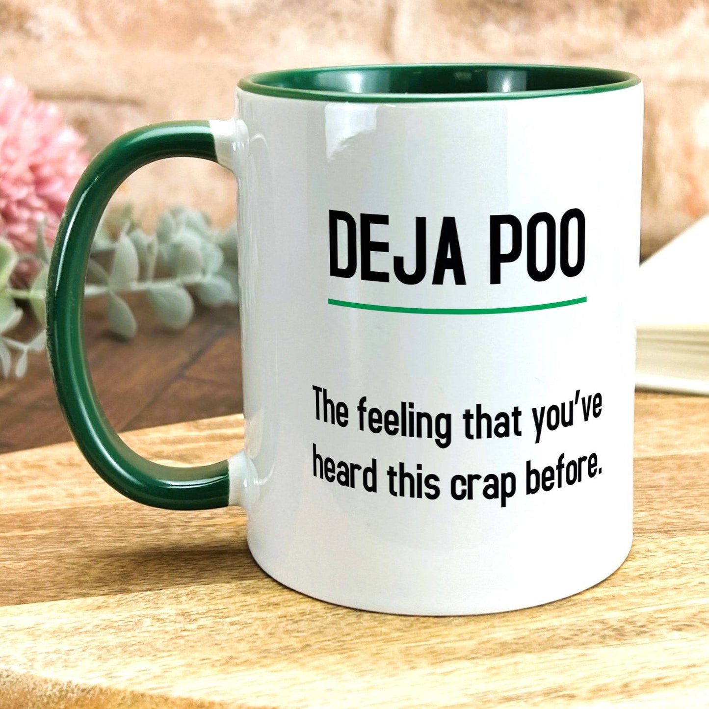 a green and white coffee mug sitting on top of a wooden table