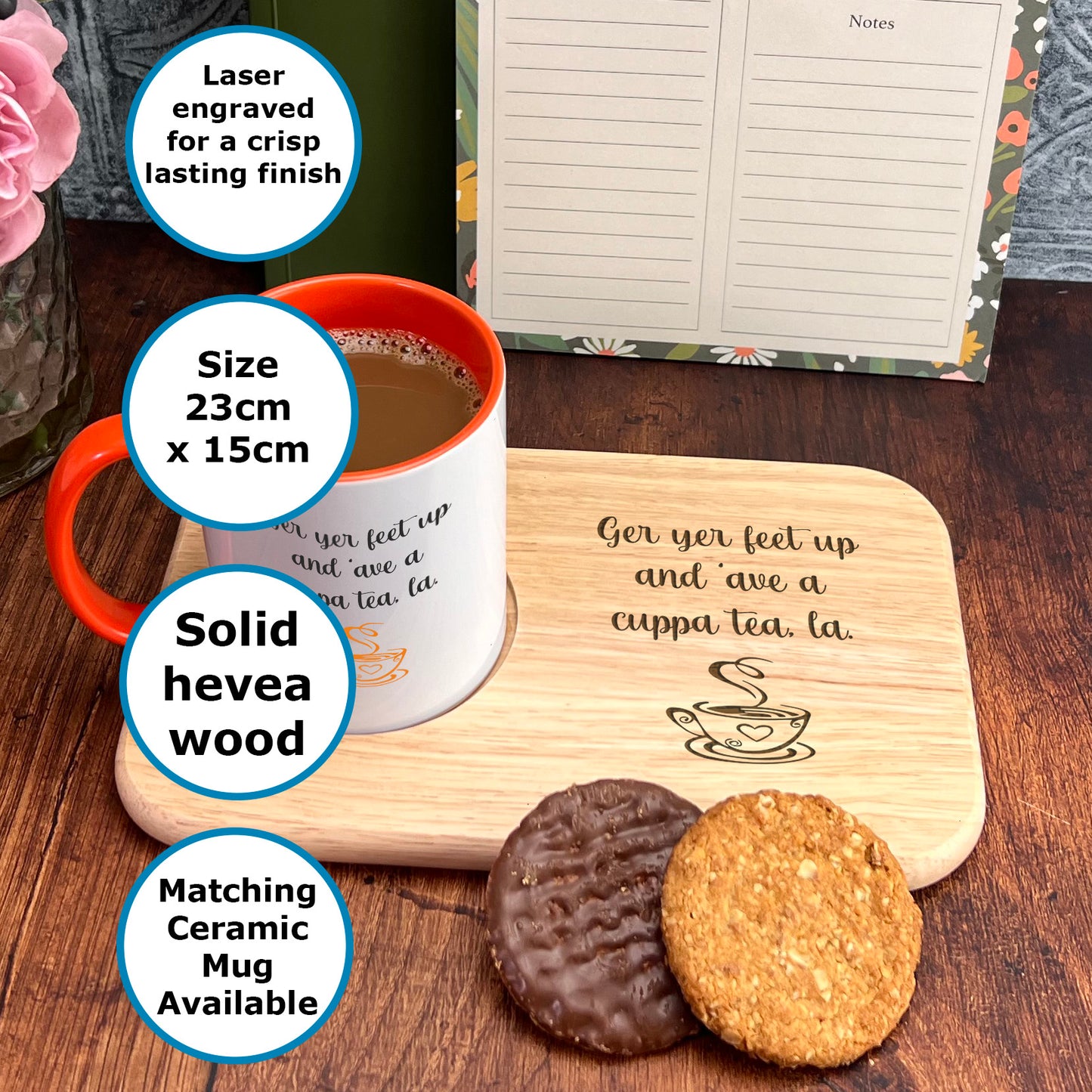 A wooden tray with a white mug and two cookies on it, along with a note pad and a pen holder.