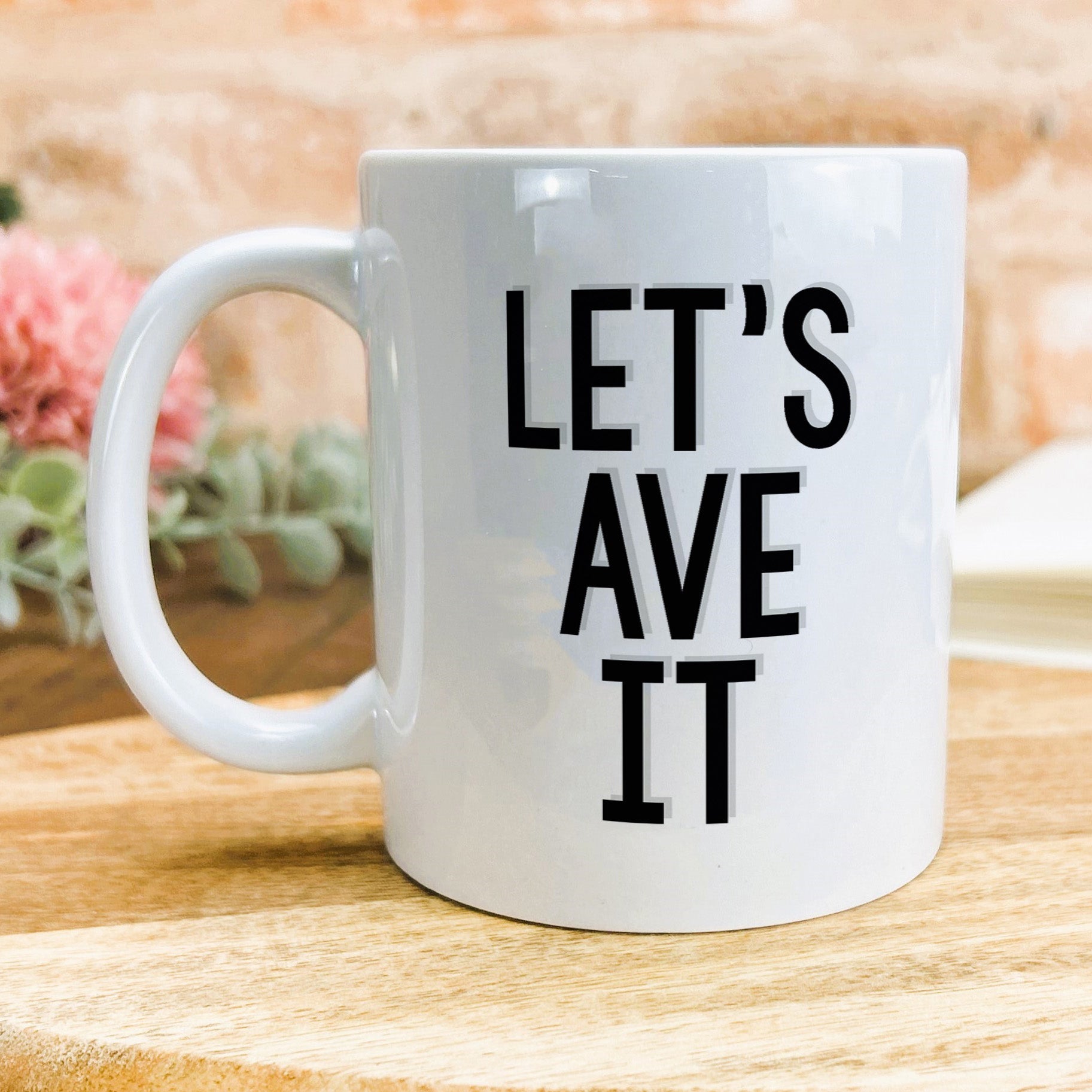 a white coffee mug with the words let's ave it printed on it