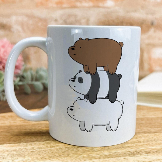 A white ceramic mug with a design featuring three cartoon polar bears stacked on top of each other.