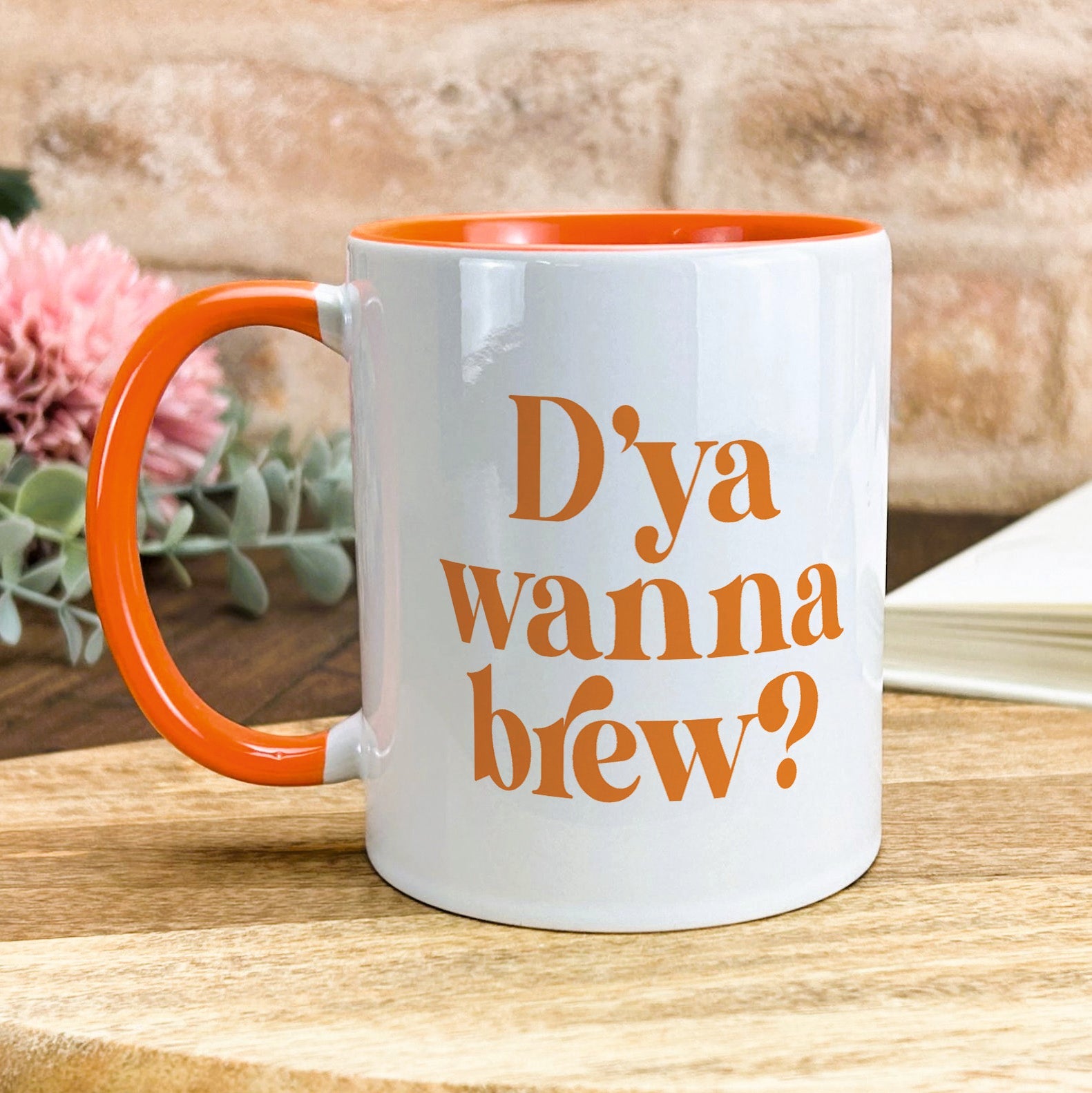 a white and orange coffee mug sitting on a table