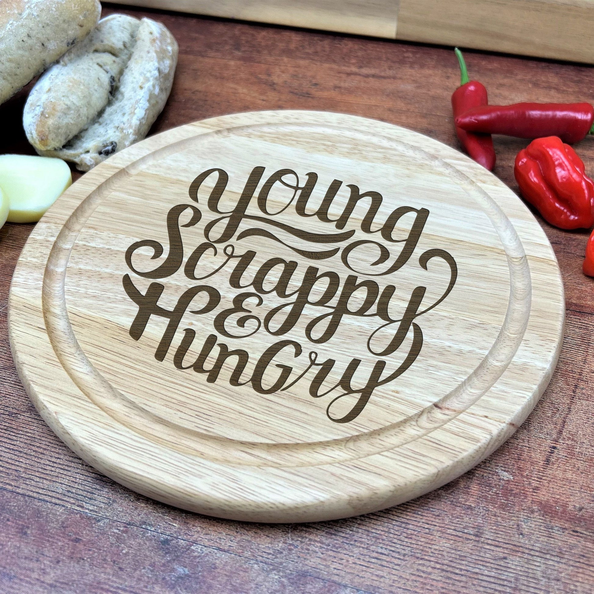 a wooden cutting board with the words young, happy, hungry on it