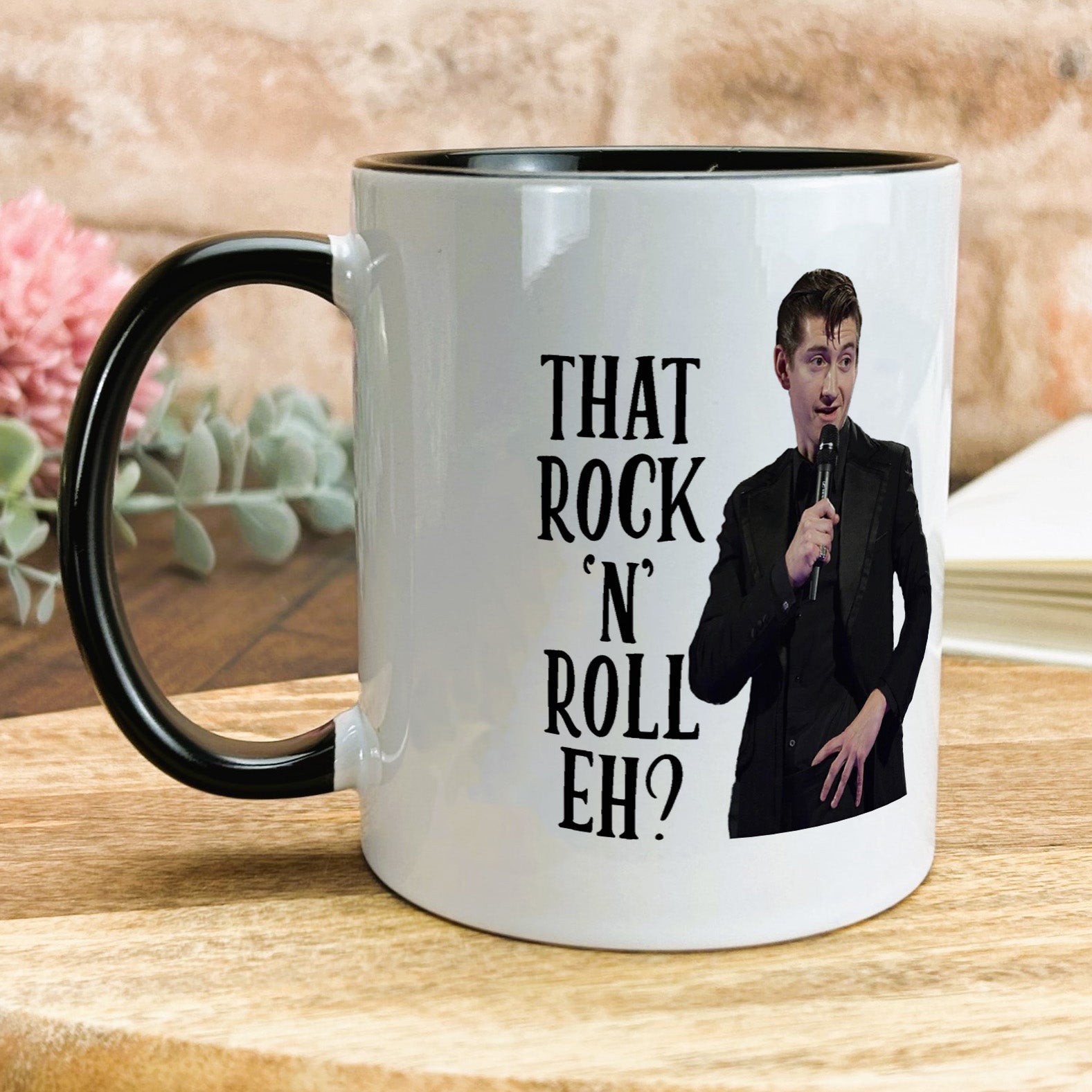 a black and white coffee mug with a picture of a man holding a microphone