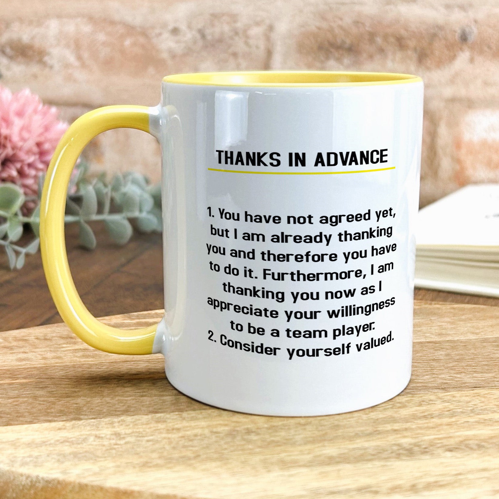 a yellow and white coffee mug sitting on top of a wooden table