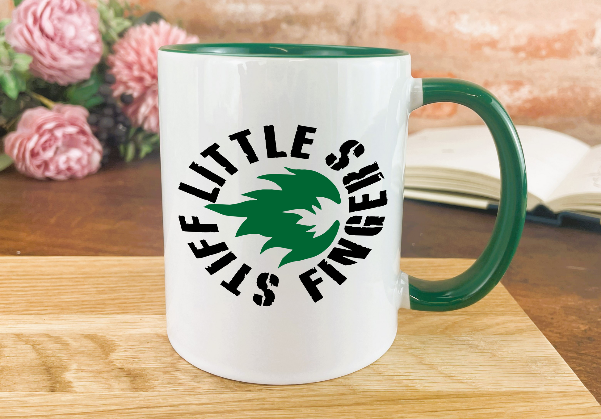 a green and white coffee mug sitting on top of a wooden table
