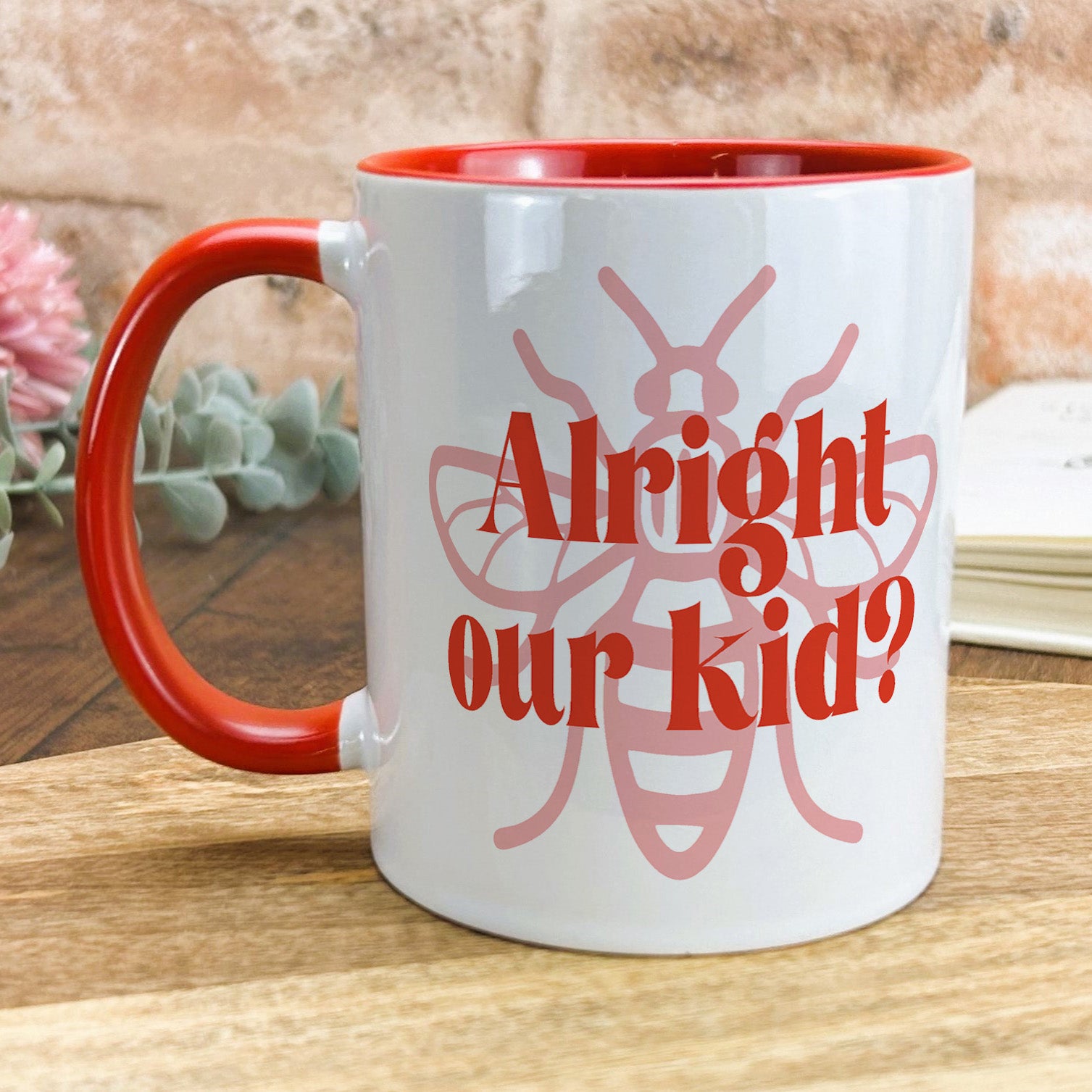 a red and white coffee mug sitting on top of a wooden table