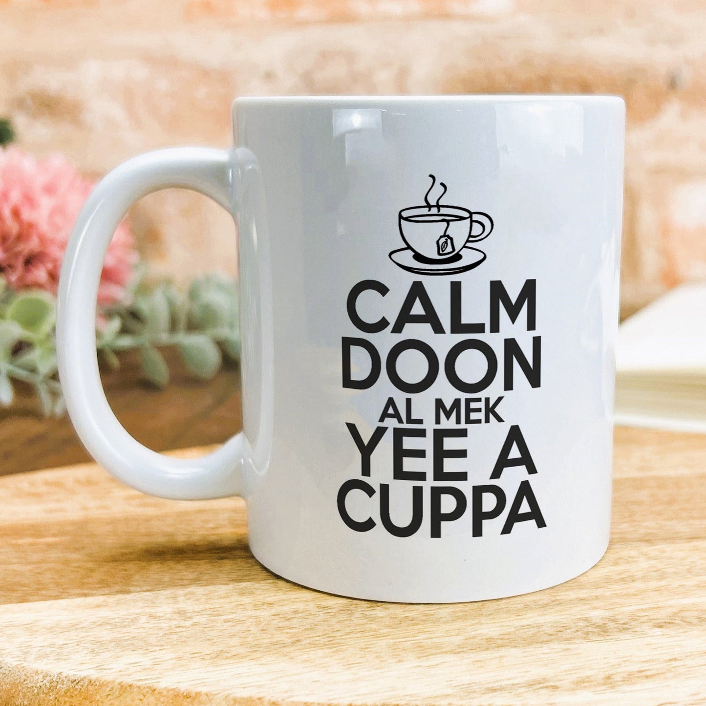 a white coffee mug sitting on top of a wooden table