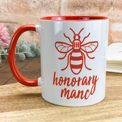 a red and white coffee mug with a bee on it