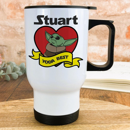 A white travel mug with a black handle, featuring a graphic of a young alien character and the text "YODA BEST" along with a heart symbol.