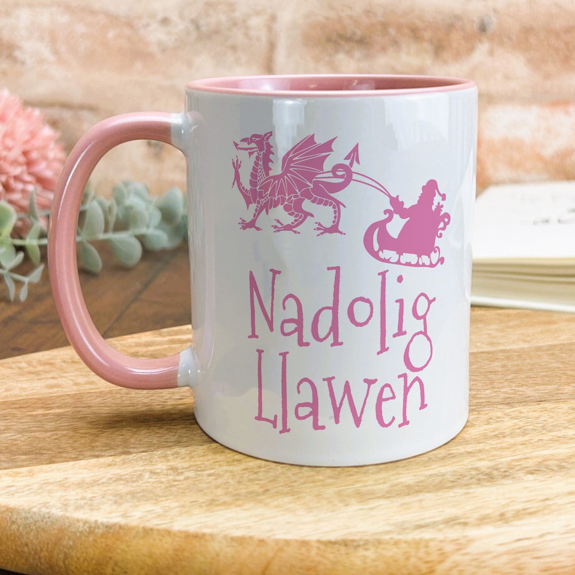 a pink and white mug sitting on top of a wooden table