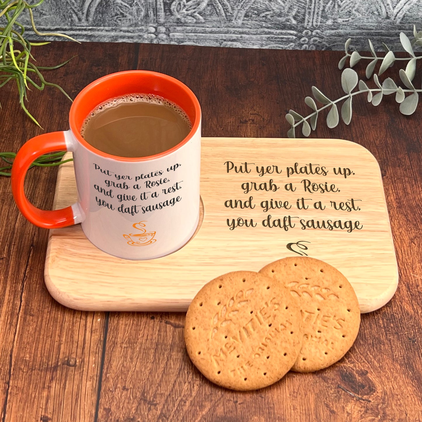 A wooden tray with a mug of coffee and two cookies, accompanied by a plant and a wooden plaque with a humorous message.