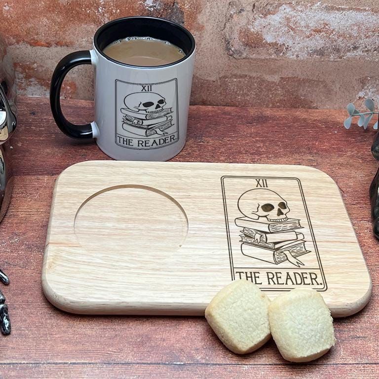 a table topped with a wooden cutting board next to a cup of coffee