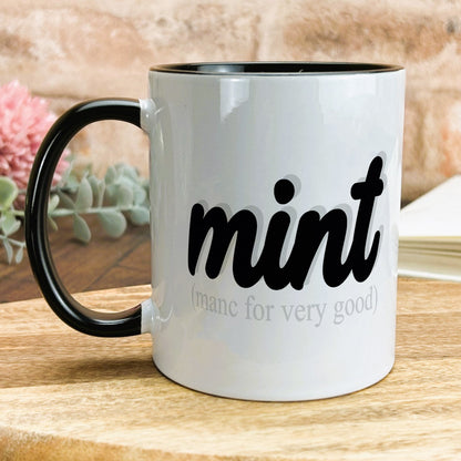 a black and white coffee mug sitting on top of a wooden table