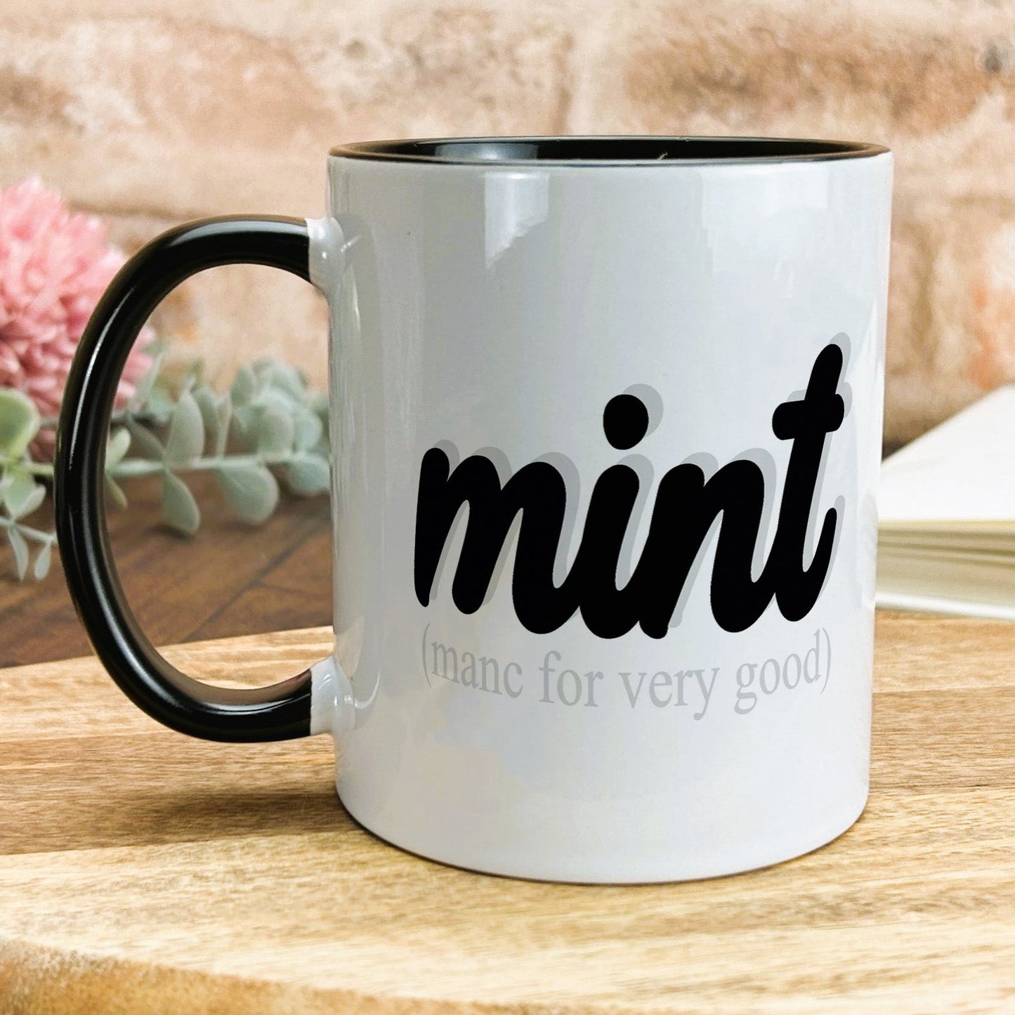 a black and white coffee mug sitting on top of a wooden table