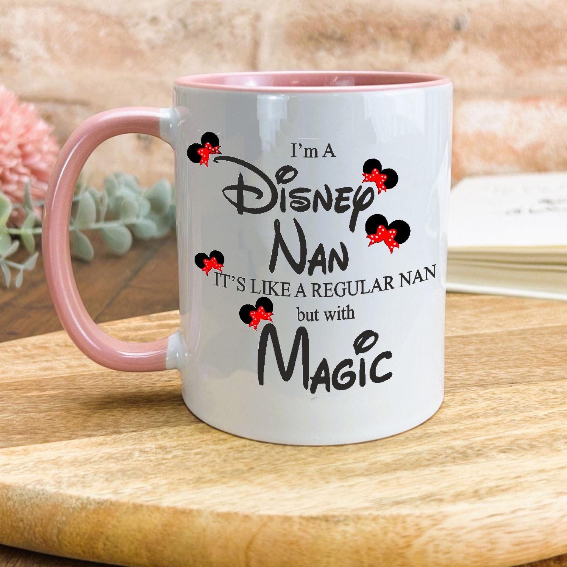 a white and pink coffee mug sitting on top of a wooden table