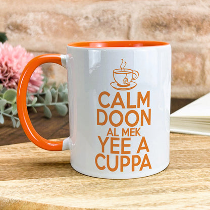 a white and orange coffee mug sitting on top of a wooden table