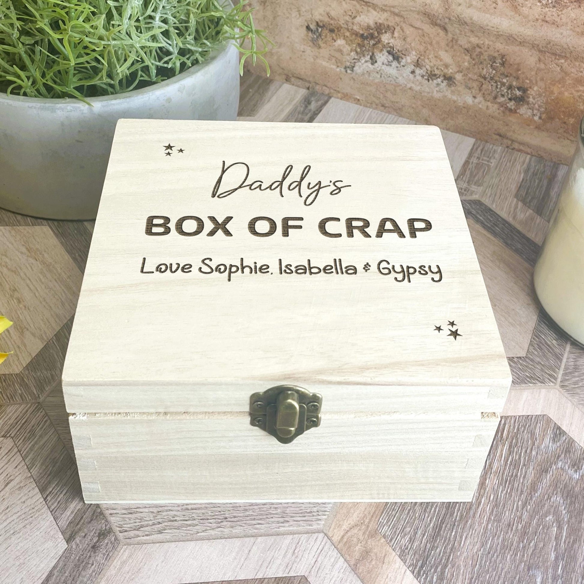 a box of crap sitting on a table next to a vase of flowers