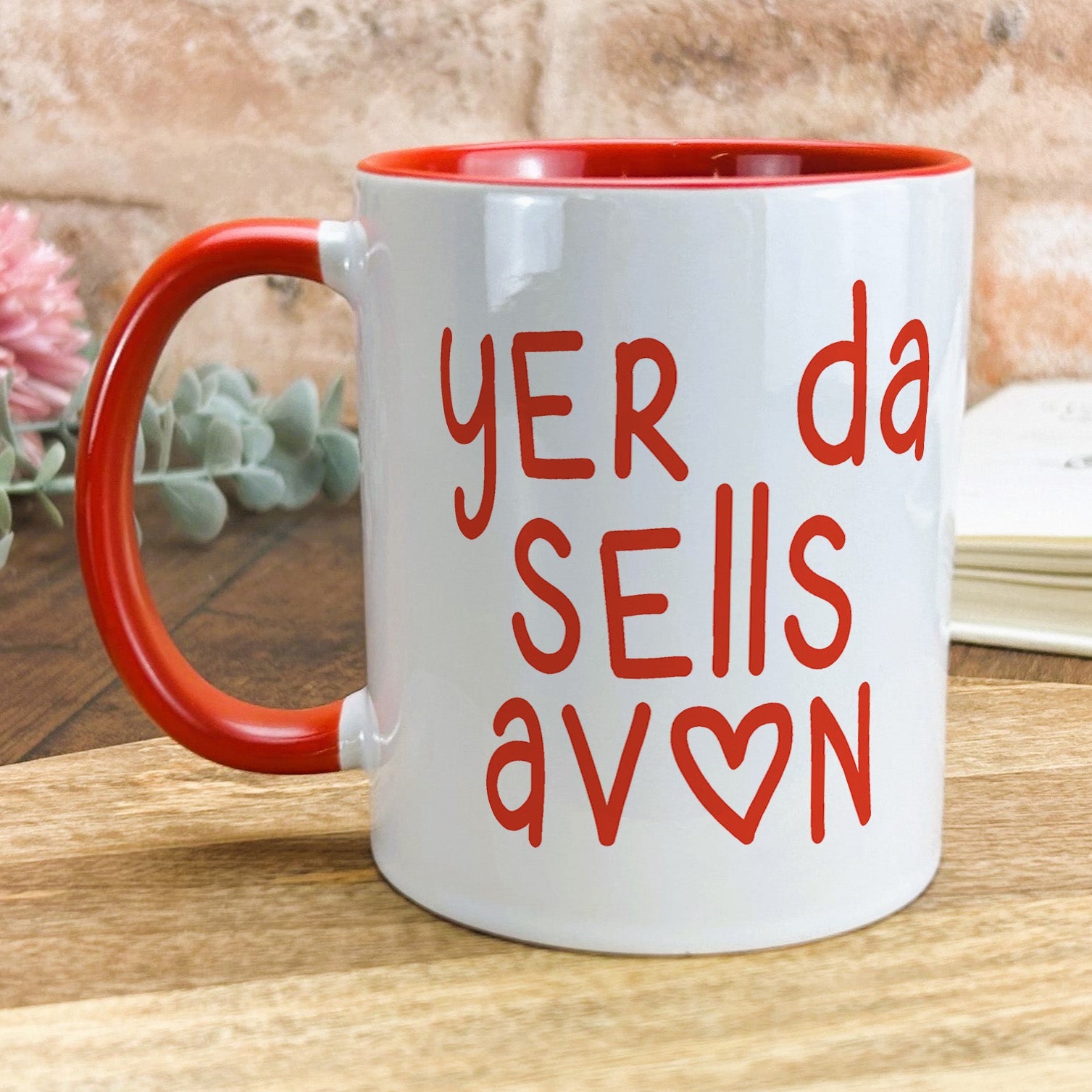 a red and white coffee mug sitting on top of a wooden table