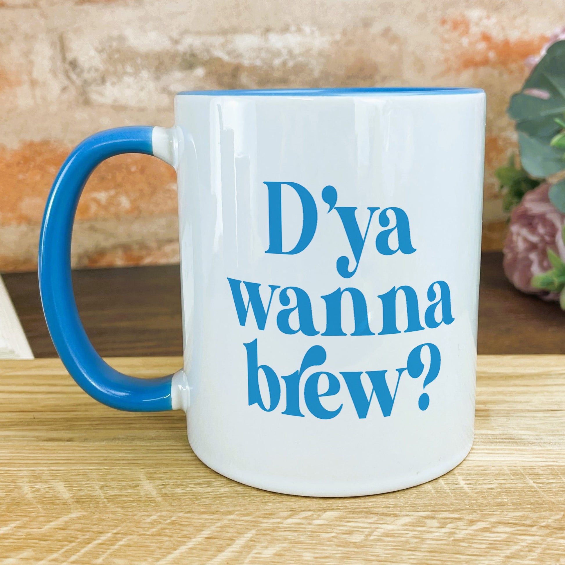 a blue and white coffee mug sitting on top of a wooden table