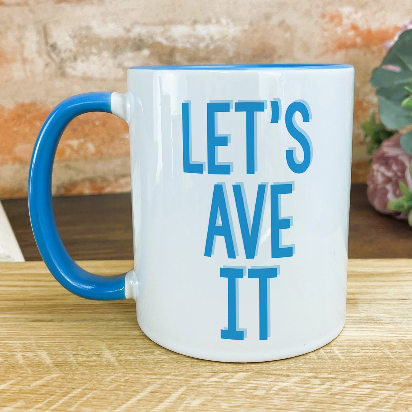 a blue and white coffee mug sitting on top of a wooden table