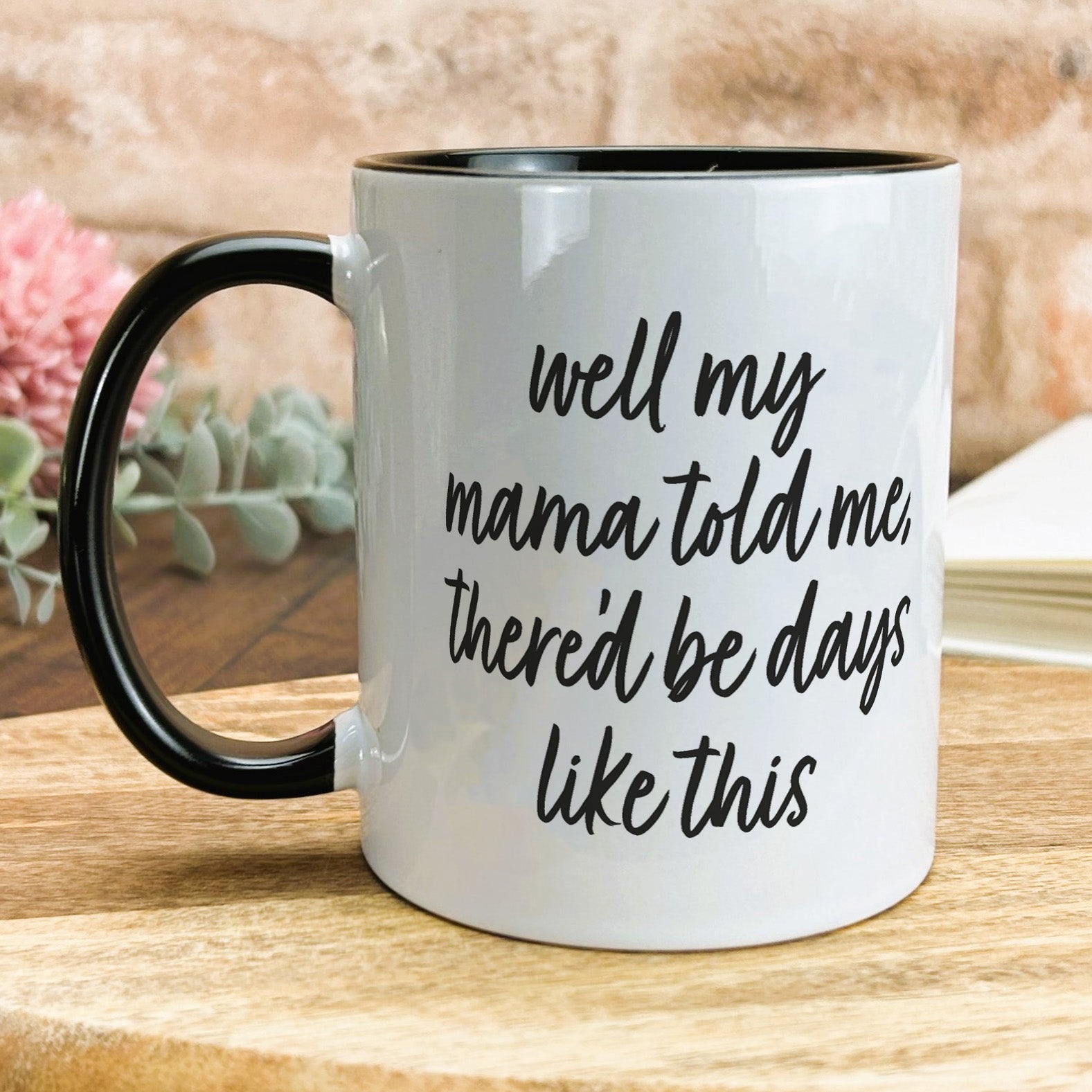 a black and white coffee mug sitting on top of a wooden table