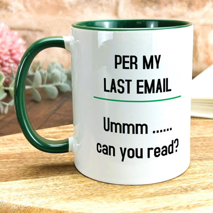 a green and white coffee mug sitting on top of a wooden table