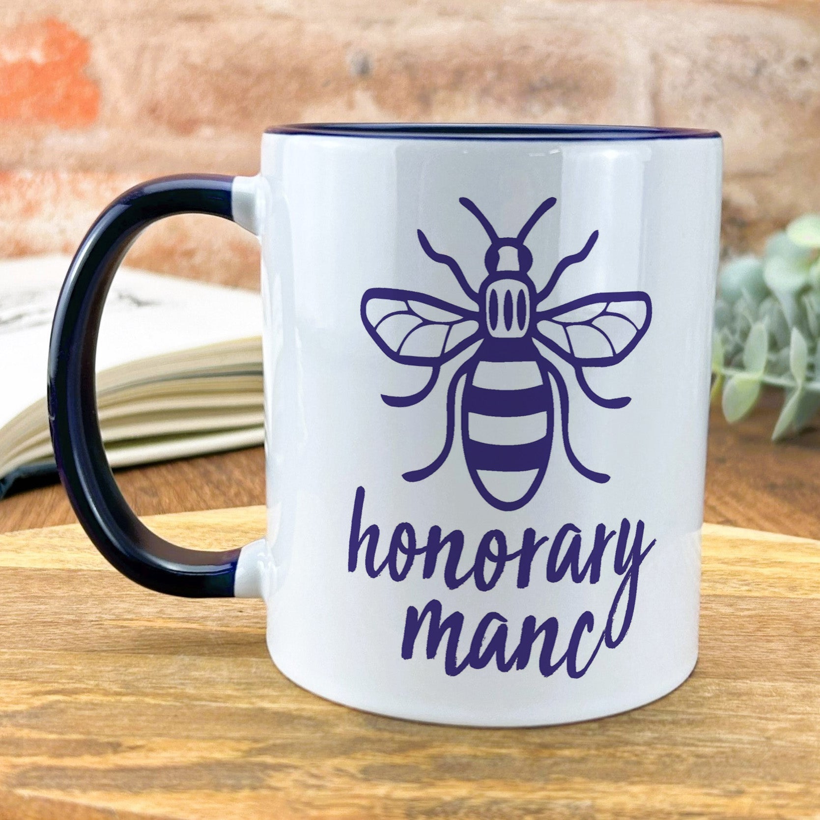 a black and white coffee mug with a bee on it
