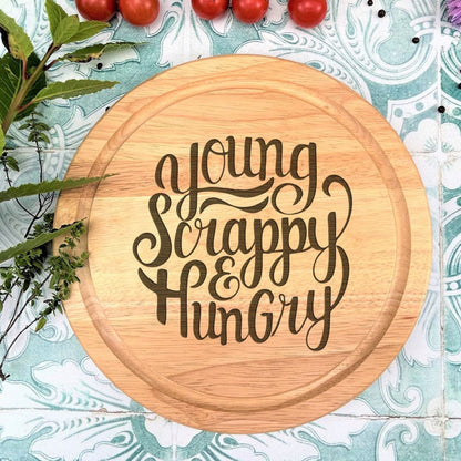 a wooden cutting board with the words young, happy, hungry on it