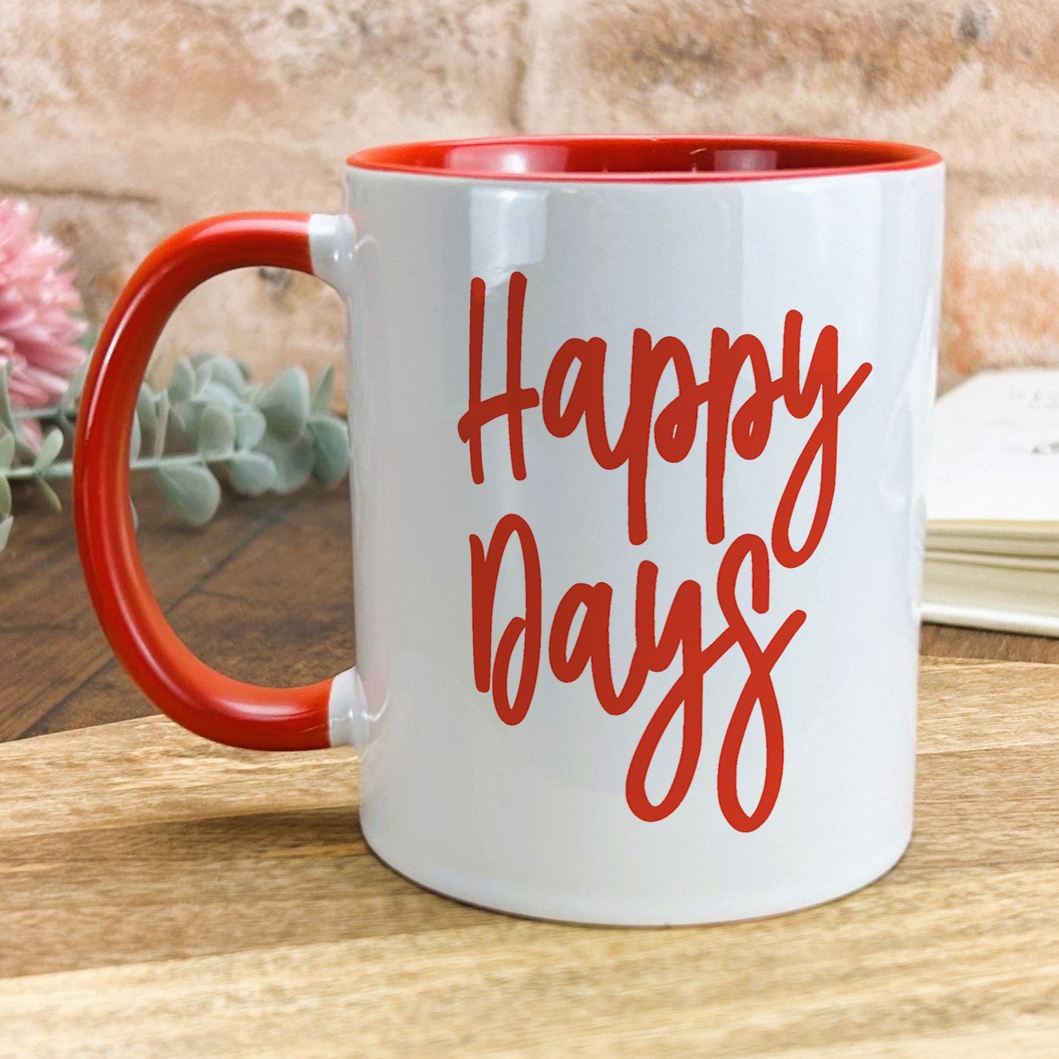 a red and white coffee mug with the words happy days on it