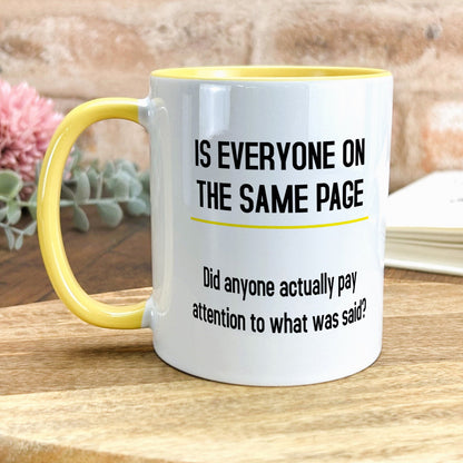 a yellow and white coffee mug sitting on top of a wooden table
