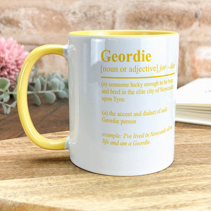 a yellow and white mug sitting on top of a wooden table