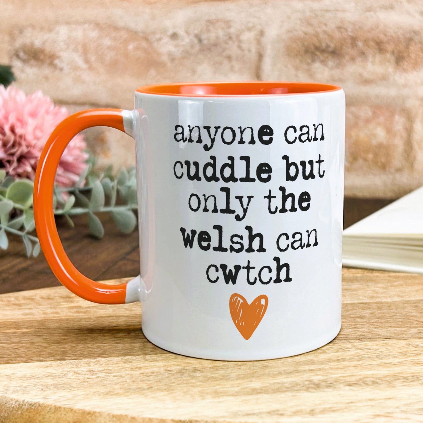 a white and orange coffee mug sitting on top of a wooden table