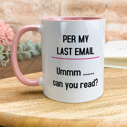 a pink and white coffee mug sitting on top of a wooden table