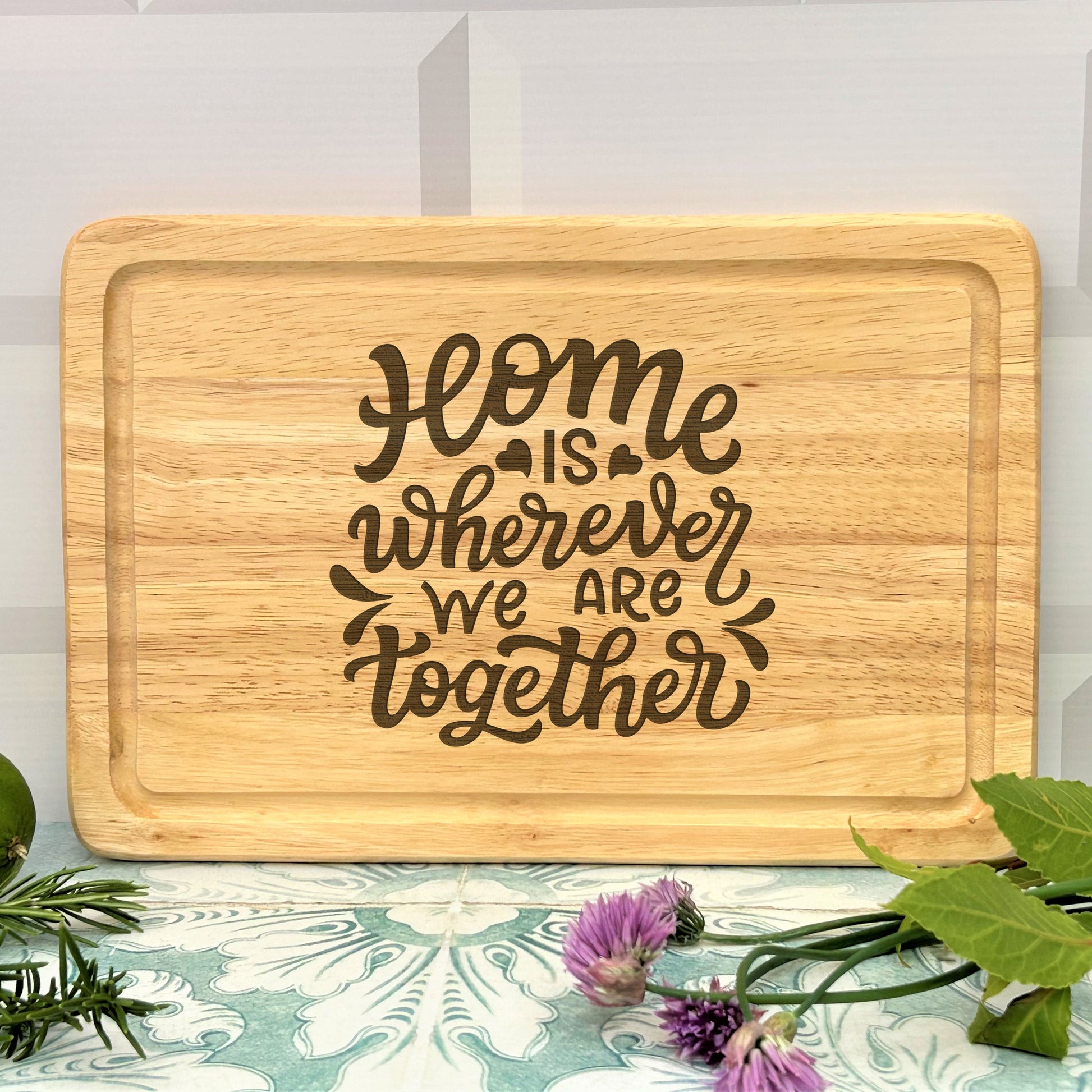 a wooden cutting board that says, home is wherever we are together