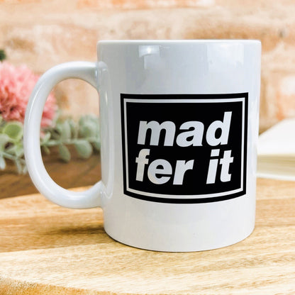 a white coffee mug sitting on top of a wooden table