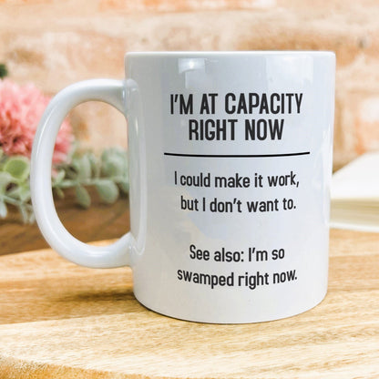 a white coffee mug sitting on top of a wooden table