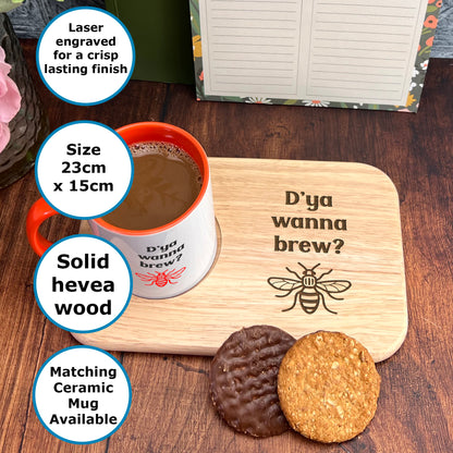 A wooden mug coaster with a printed design and a cup of coffee on it, along with a plate of cookies and a note.
