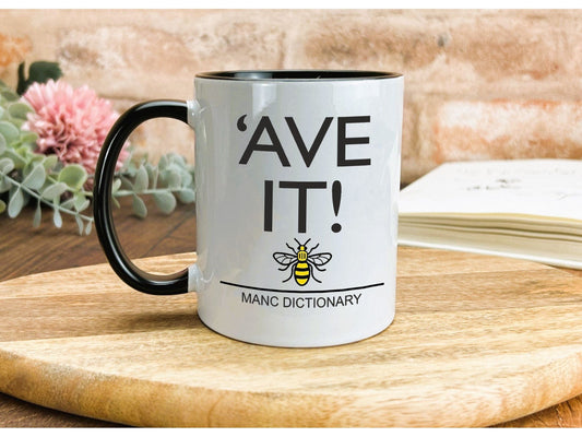 a white and black coffee mug sitting on top of a wooden table