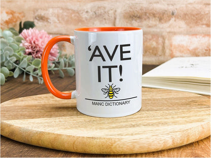 a white and orange coffee mug sitting on top of a wooden table